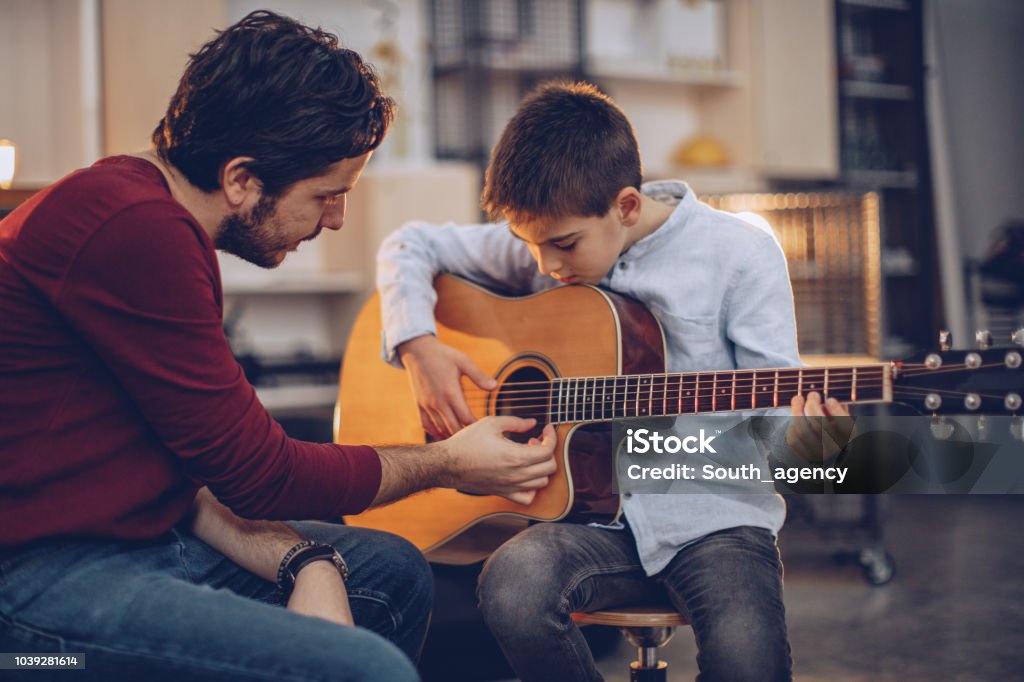 man teaching guitar lessons to student

